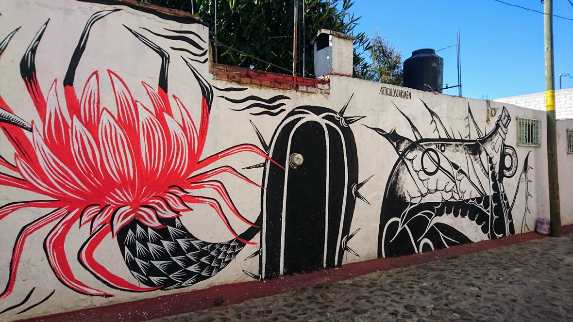 Street art of a cactus and mezcal bottle on a wall